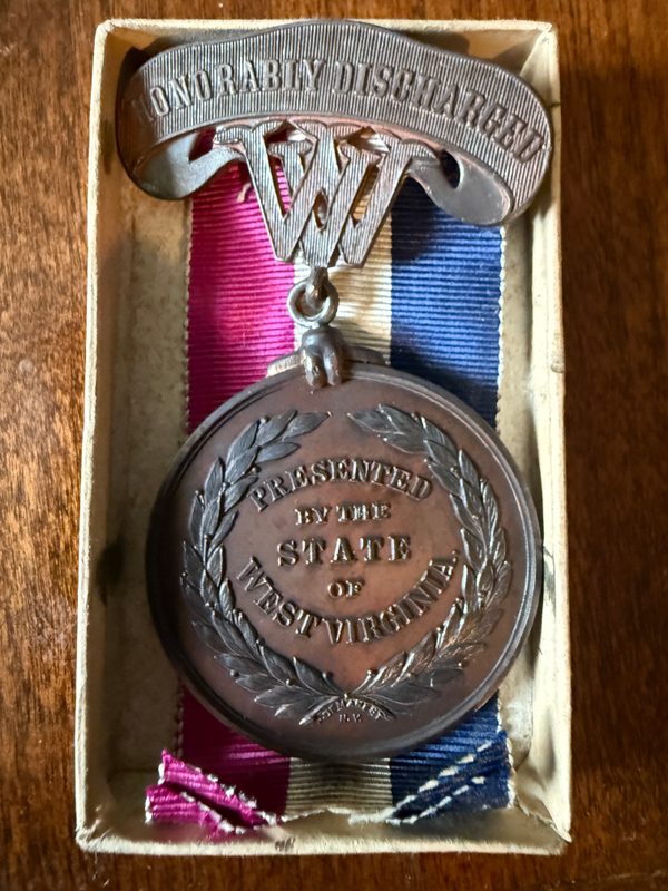 Reverse of the medal inscribed Presented by the State of West Virginia, with its red, white, and blue ribbon