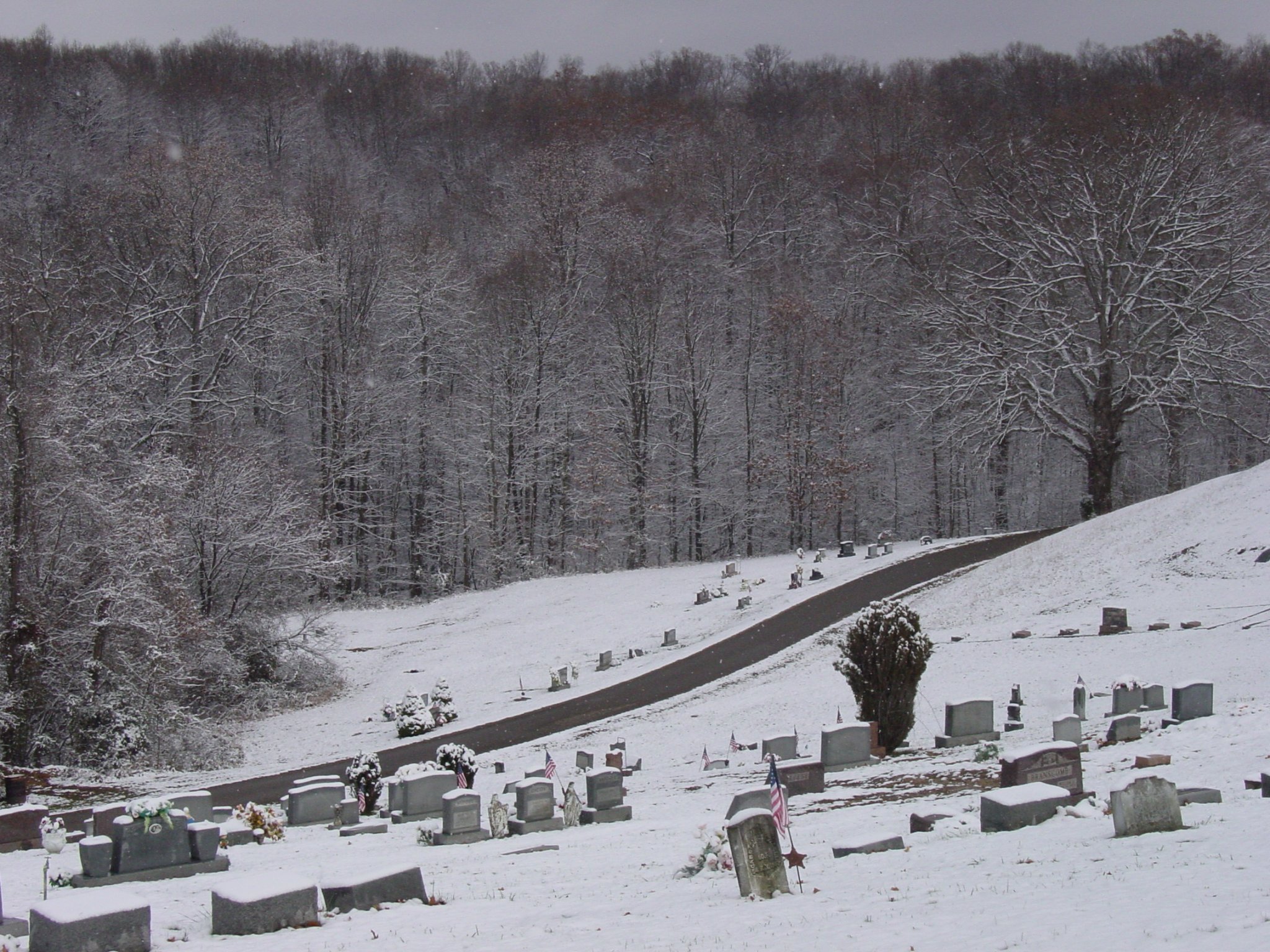 Cannon and gravestones in snowy Ridgewood Cemetery